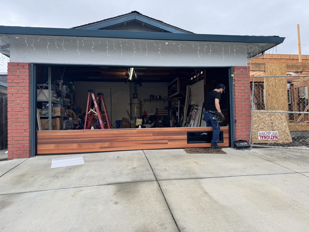 Technician installing a new wood-look garage door